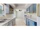 Well-lit kitchen featuring tile floors, blue cabinets, and essential appliances at 624 American Heritage Pkwy, Orlando, FL 32809
