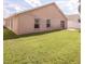 Spacious backyard with lush green lawn and a sliding glass door leading to the home's interior at 631 Lady Diana Dr, Davenport, FL 33837