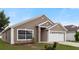 Charming single-story home with a well-maintained lawn and a two-car garage in a sunny neighborhood at 631 Lady Diana Dr, Davenport, FL 33837