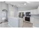 Modern kitchen with white cabinets, stainless steel appliances, and a breakfast bar overlooking the living area at 631 Lady Diana Dr, Davenport, FL 33837