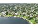 An aerial view of a lakefront home with a private pool, boat dock, and lush landscaping at 7145 Lake Dr, Orlando, FL 32809