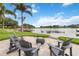 Picturesque backyard overlooking the water, complete with a cozy seating area and lush tropical landscaping at 7145 Lake Dr, Orlando, FL 32809