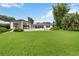 Expansive backyard featuring a pristine lawn, covered patio, and modern architecture, ideal for outdoor entertaining at 7145 Lake Dr, Orlando, FL 32809