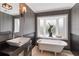 Chic bathroom with wainscoting, pedestal tub, and a bright bay window at 7145 Lake Dr, Orlando, FL 32809