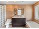 Bright bathroom featuring double sink vanity, modern mirror, separate toilet and tub, and light tile flooring at 7145 Lake Dr, Orlando, FL 32809