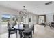 Dining area with modern chandelier and travertine flooring, offering access to outdoor views at 7145 Lake Dr, Orlando, FL 32809
