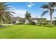 Beautiful single-story home with lush green lawn, mature palm trees, and well-maintained landscaping at 7145 Lake Dr, Orlando, FL 32809