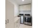 Well-lit laundry room with modern appliances, cabinets, drawers, and marble tile flooring at 7145 Lake Dr, Orlando, FL 32809