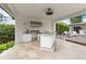 A full outdoor kitchen with stainless steel appliances, counter seating, and an attached patio area at 7145 Lake Dr, Orlando, FL 32809