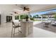 A covered outdoor kitchen with an island, barstools and beautiful views of the lake at 7145 Lake Dr, Orlando, FL 32809