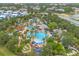 Beautiful aerial view of a resort-style pool area with palm trees, water slides, and lounge chairs at 7740 Sandy Ridge Dr # 124, Reunion, FL 34747