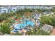 Expansive aerial view showcasing a large resort-style pool surrounded by tropical landscaping and condominiums at 7740 Sandy Ridge Dr # 124, Reunion, FL 34747
