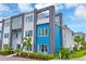 Modern townhome with striking blue and grey exterior and well-maintained landscaping at 7740 Sandy Ridge Dr # 124, Reunion, FL 34747