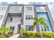 Contemporary townhome featuring sleek gray and blue exterior, lush landscaping, and modern architectural details at 7740 Sandy Ridge Dr # 124, Reunion, FL 34747