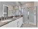 Bright main bathroom featuring double sinks, frameless shower, sleek countertops, and modern fixtures at 7740 Sandy Ridge Dr # 124, Reunion, FL 34747