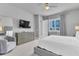 Modern main bedroom with plush chair, sleek dresser and flatscreen TV, bathed in natural light at 7740 Sandy Ridge Dr # 124, Reunion, FL 34747