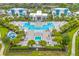 Stunning aerial view of a symmetrical pool area, palm trees, and modern condo buildings at 7740 Sandy Ridge Dr # 124, Reunion, FL 34747