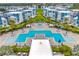 Aerial view of a symmetrical pool area with lounge chairs, palm trees, and modern condo buildings at 7740 Sandy Ridge Dr # 124, Reunion, FL 34747