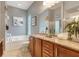 Dual vanity bathroom featuring granite countertops, soaker tub, and natural light at 7918 Esta Ln, Orlando, FL 32827
