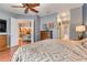 View of the main bedroom offering a ceiling fan, wood floors, and a view into the kitchen at 7918 Esta Ln, Orlando, FL 32827