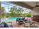 Outdoor screened-in pool area with comfortable lounge seating and a scenic view at 7918 Esta Ln, Orlando, FL 32827