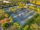 Aerial view of community tennis courts surrounded by lush palm trees and landscaping near a pond at 7918 Esta Ln, Orlando, FL 32827