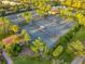 Aerial view of community tennis courts surrounded by lush palm trees and landscaping near a pond at 7918 Esta Ln, Orlando, FL 32827
