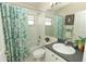 Neutral bathroom featuring a vanity sink, commode, and shower/tub with floral curtain at 8093 Indian Creek Blvd, Kissimmee, FL 34747