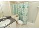 Neutral bathroom featuring a vanity sink, commode, and shower/tub with floral curtain at 8093 Indian Creek Blvd, Kissimmee, FL 34747