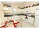 Well-lit kitchen with white appliances, dark countertops, decor atop the cabinets, and breakfast table at 8093 Indian Creek Blvd, Kissimmee, FL 34747