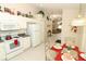 Open kitchen with tile flooring, white appliances, and breakfast table near a view into the living room at 8093 Indian Creek Blvd, Kissimmee, FL 34747