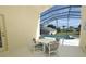 Covered patio seating area overlooking the screened-in pool and landscaped backyard at 8093 Indian Creek Blvd, Kissimmee, FL 34747