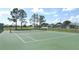 Community tennis court surrounded by fence and overlooking community houses at 8093 Indian Creek Blvd, Kissimmee, FL 34747