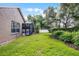 Lush backyard showcases mature trees, manicured bushes, and the screened-in pool area at 831 Royalwood Ln, Oviedo, FL 32765