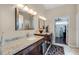 Bathroom featuring double sinks and granite countertops and walk-in closet access at 831 Royalwood Ln, Oviedo, FL 32765