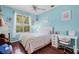 Bedroom with light blue walls, wood floors, desk and a window with plantation shutters at 831 Royalwood Ln, Oviedo, FL 32765