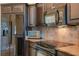 Kitchen area showcasing stainless steel appliances and dark wood cabinets with granite countertops at 831 Royalwood Ln, Oviedo, FL 32765