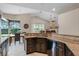 Open kitchen and dining area with granite countertops, stainless appliances, and tile flooring at 831 Royalwood Ln, Oviedo, FL 32765