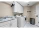 Laundry room features a front-load washer and dryer, granite countertops, and white cabinetry at 831 Royalwood Ln, Oviedo, FL 32765