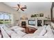 Spacious living room with a fireplace, ceiling fan, and large sectional sofa at 831 Royalwood Ln, Oviedo, FL 32765