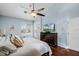 Light-filled main bedroom features wood floors, ceiling fan, and access to the bathroom at 831 Royalwood Ln, Oviedo, FL 32765
