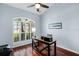 Office featuring a spacious desk, wood floors, shuttered windows, and light blue walls at 831 Royalwood Ln, Oviedo, FL 32765