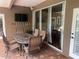 Covered patio with outdoor furniture, including an outdoor table and chairs, and a mounted TV, perfect for entertaining guests at 831 Royalwood Ln, Oviedo, FL 32765