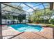 Beautiful pool with brick trim, a waterfall feature, and lush landscaping at 831 Royalwood Ln, Oviedo, FL 32765