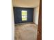 Cozy bedroom with a large window, carpeted floors, and a calming blue accent wall at 1050 Reading Ct, Winter Park, FL 32792