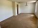 Spacious living room featuring neutral carpeting, a modern chandelier, and ample natural light from a window at 1050 Reading Ct, Winter Park, FL 32792