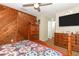 Bedroom with wood paneling, ceiling fan, dresser, and tv at 1078 Aaron Dr, Deltona, FL 32725