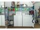 Functional laundry room featuring a washer, dryer, utility sink, and ample storage shelves at 1078 Aaron Dr, Deltona, FL 32725
