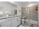 Bathroom with a granite countertop vanity, a glass-enclosed shower with a built-in seat, and modern fixtures at 11054 Hanlon Terrace Aly, Winter Garden, FL 34787