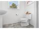 Well-lit half bathroom with white fixtures, tile flooring, and a clean, modern design at 11054 Hanlon Terrace Aly, Winter Garden, FL 34787